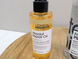 a bottle of alcohol next to a bottle of hair oil on a table
