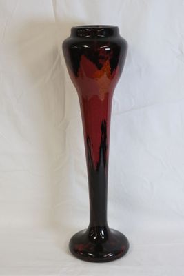 a black and red vase sitting on a white surface