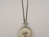 a close up of a pocket watch on a chain on a white surface