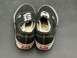 pair of black and white shoes with white laces on a gray surface