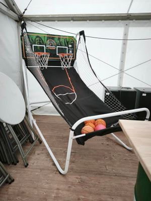 un hamac sur lequel sont posés un panier de basket et un ballon de basket