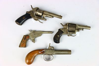 three old revolvers sitting on top of a table next to each other