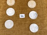 Plusieurs types de pièces de monnaie sont disposés en rangée sur une table