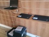 two laptops sitting on a shelf in the corner of a room