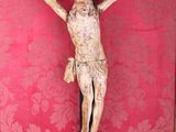 a statue of jesus on a cross on a red wall
