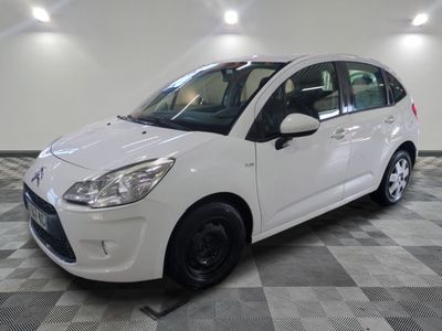 la petite voiture blanche est garée sur un sol en damier