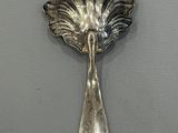 a silver spoon with a leaf on it on a table