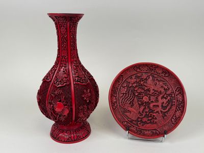 un vase rouge et une assiette placés l'un à côté de l'autre