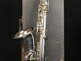 an old silver saxophone with a silver case on a black background