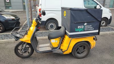 a yellow scooter that is parked on the side of the street
