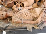 une photo représentant une statue en bois d'une femme dont la tête repose sur une table