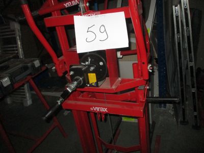 une machine rouge avec une pancarte dessus, dans un garage