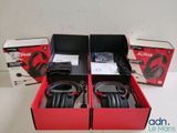 two boxes of headphones sitting on top of a table next to each other