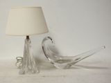 une lampe et un oiseau en verre posés sur une table