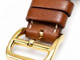 a close up of a brown leather watch strap with a gold buckle