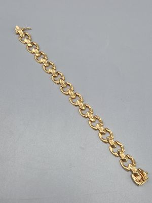 un bracelet à chaîne en or avec une breloque en forme de cœur
