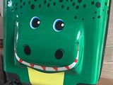 une valise verte ornée d'un alligator de bande dessinée