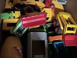 a cardboard box filled with toys like construction trucks and dump trucks