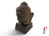 sculpture of a head of a buddha on a wooden base