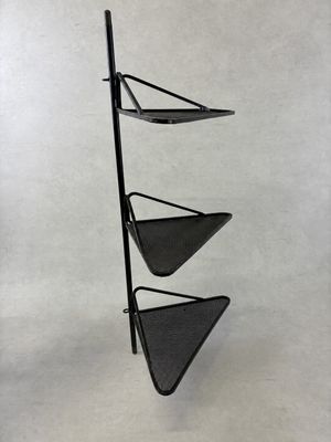 a black metal shelf with three triangular shaped shelves on it