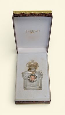 perfume bottle in a box on a table with a white background