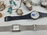 many different watches and bracelets laid out on a table
