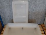 une baignoire blanche posée sur une palette à côté de toilettes