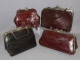 four pieces of leather purses are lined up on a white surface