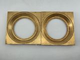 a pair of brass plate with two circular holes in the middle