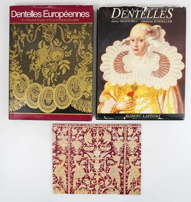 trois livres posés sur une table blanche, avec une couverture rouge et dorée