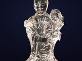 a glass figurine of a woman holding a child