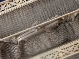 a silver purse that is sitting on a table