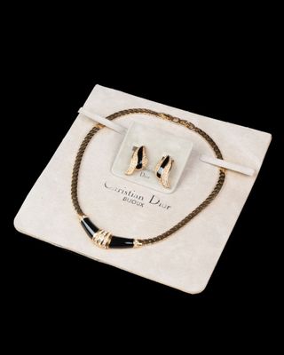 a close up of a necklace and a bracelet on a white bag