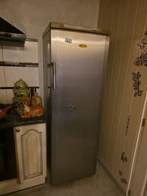 un réfrigérateur dans un coin de la cuisine, à côté d'un évier