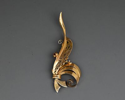a close up of a gold plated pendant on a gray surface