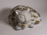 a white cat figurine sitting on a white surface