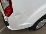 the rear end of a white truck with a denting dent