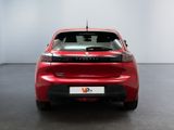 the rear end of a red car in a room with a white wall