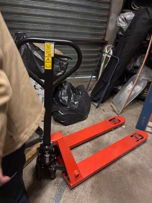 a man standing next to a pallet in a garage