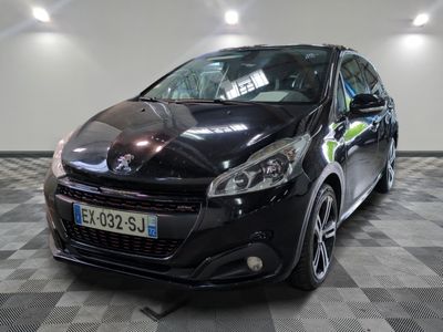 La petite voiture noire est garée dans le garage, sur le sol à damier.