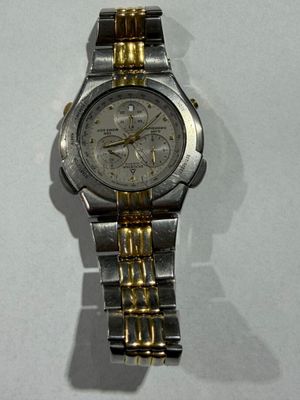 a silver and gold watch on a white surface