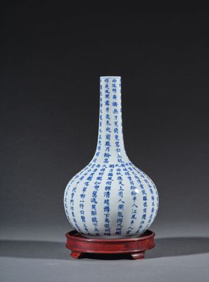 vase bleu et blanc reposant sur un socle rouge, posé sur une surface grise