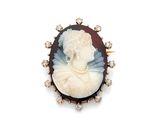 Une broche représente une femme en robe blanche.
