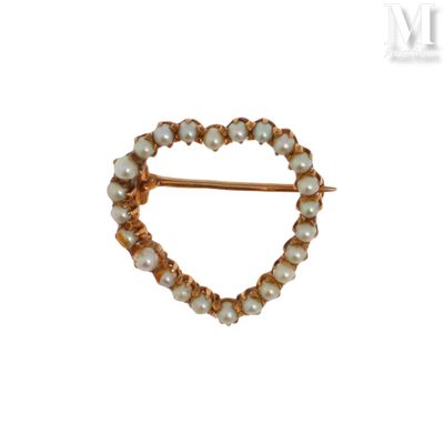 un gros plan d'une broche ornée de perles sur fond blanc
