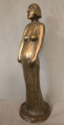 statue d'une femme en robe longue, debout, les mains sur les hanches