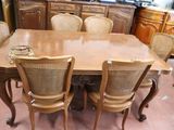 a large wooden table with six chairs and a cabinet in the background