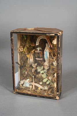 a small box with a doll in it on a table