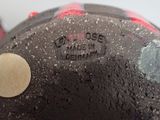 a close up of a black and red vase with a yellow dot on it