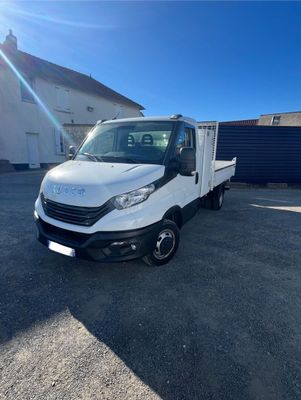 un camion blanc garé sur un parking à côté d'un immeuble