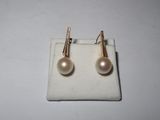 pair of pearl and gold earrings on a white cloth